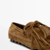 Mocassins en daim refendu avec franges et pompons Mocassins en daim refendu avec franges et pompons